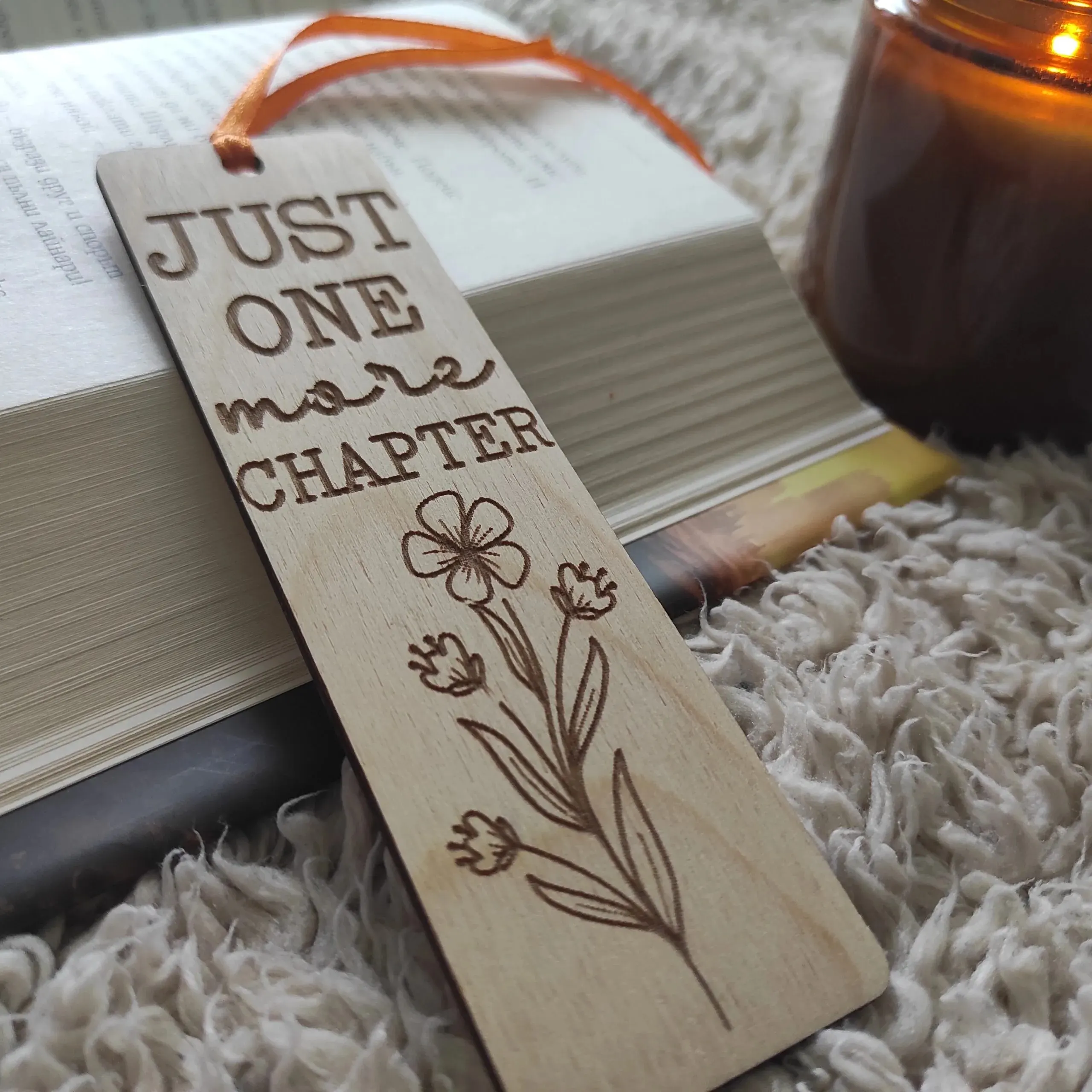 Дървен книгоразделител Just one more chapter върху отворена книга